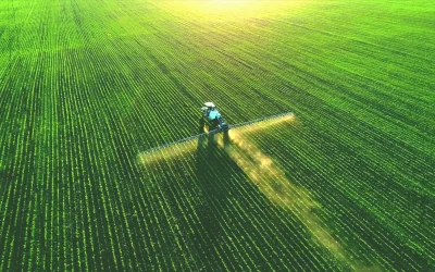Drone view of a tractor spraying a green field, illustrating USDA's SCION government IT modernization project