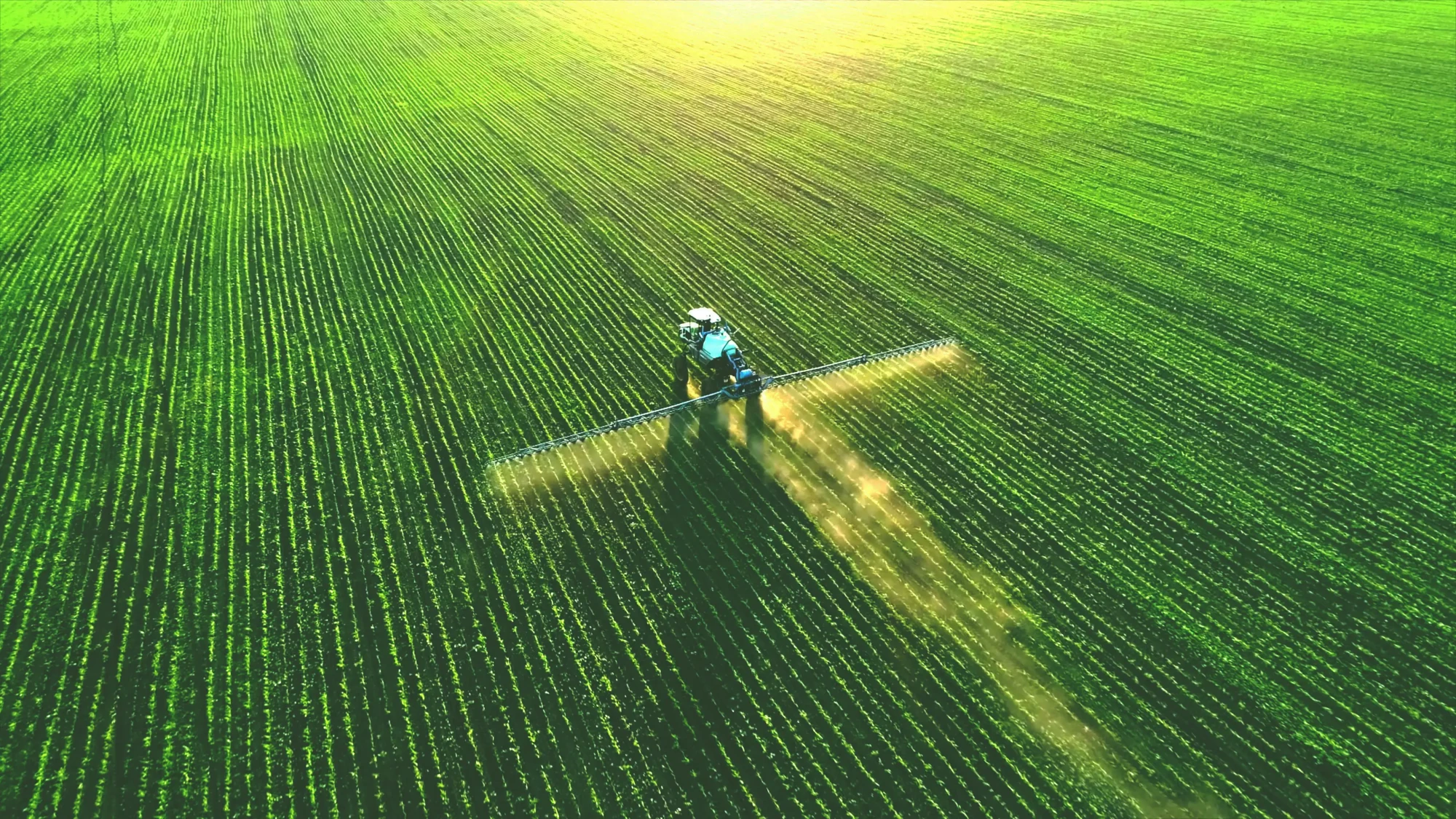 Drone view of a tractor spraying a green field, illustrating USDA's SCION government IT modernization project