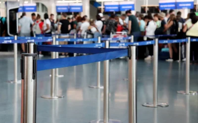 Travelers wait in a roped queue at an airport check-in area, the kind of friction government CX projects aim to reduce